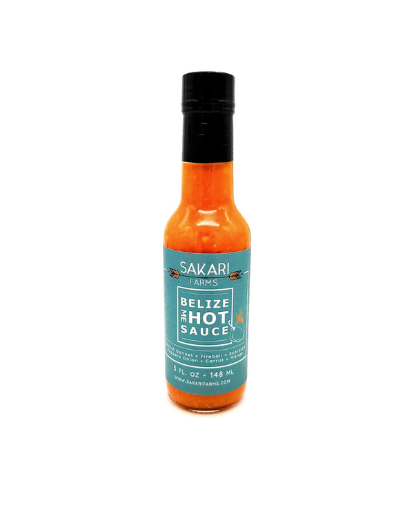 A 5oz bottle of bright orange hot sauce on a white background. The label reads SAKARI FARMS, BELIZE ME HOT SAUCE.