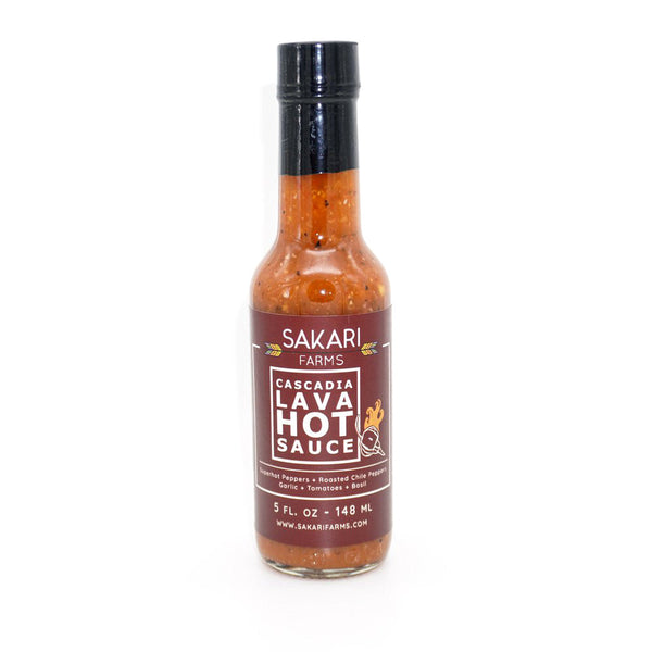 A 5oz bottle of medium orange hot sauce with black and white flecks on a white background. The label reads SAKARI FARMS CASCADIA LAVA HOT SAUCE.