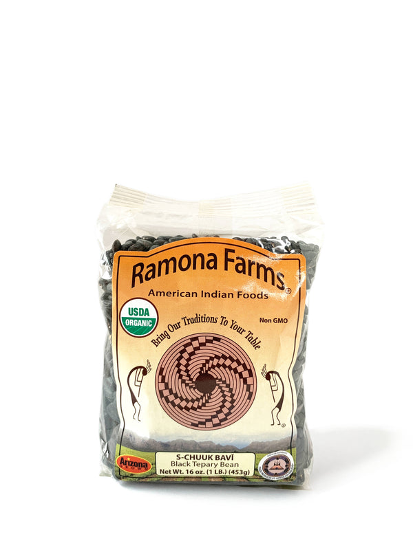 A white background with a package of Black Teppary Beans (S-CHUUK BAVÍ) from Ramona Farms.